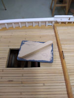 Base of aft hatch (and other structures) has a diagonal bar on the underside. The bar fits in the opening in the deck and allows the removal of the structure for e peek below deck.